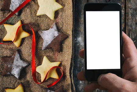 Christmas star shape cookies and blank screen on smart phoneの写真素材