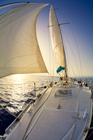 people on a sail boat at the sunsetの写真素材