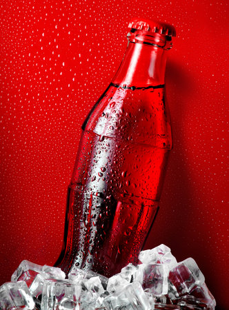Cola in ice on a red backgroundの写真素材