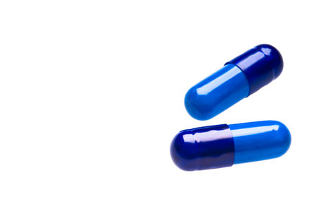 Two blue capsules over whiteの写真素材