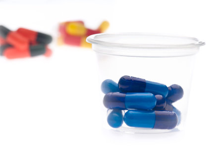 Colorful tablets, capsules in a container, over whiteの写真素材