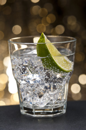 Gin Tonic Cocktail in front of a brown gold backgroundの写真素材