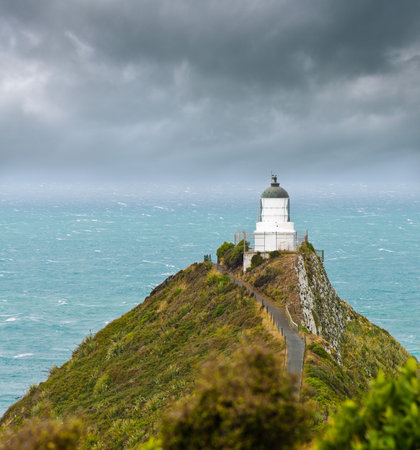 Nugget Point Light House an dark clouds in the sky, Catlins, New Zealandの写真素材