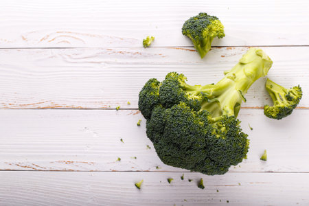 Fresh raw broccoli on white wooden background, flat lay with copy spaceの写真素材
