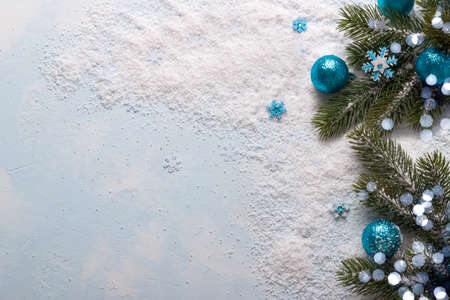 Christmas and New Year background.Fir tree branch with festive blue balls and snow flakes on snow. Top viewの写真素材