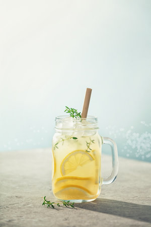 Summer drink with lemon and rosemary close up. Summer refreshing drink. Cold detox water with lemonの写真素材