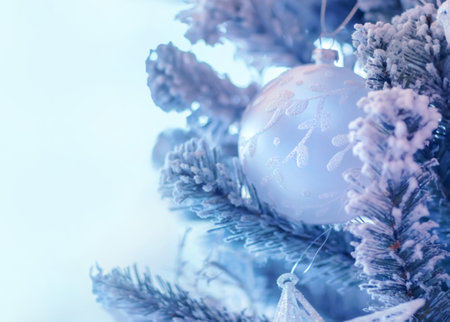 Beautiful Christmas tree border, gentle white bauble hanging on pine twig covered with snow over clear blue background..の写真素材