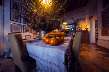 Thanksgiving Day in Family House. Festive Table with Pumpkins and Flowers Decoration. Traditional American Holiday. Autumn Harvest Celebration.の写真素材