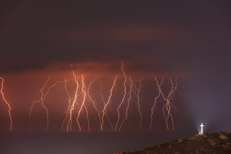 Amazing Landscape of a Beautiful Zippers in Dark Night Sky. Illuminated Cross Standing on top of the...