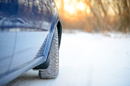 Close-up Image of Winter Car Wheel on the Snowy Road. Drive Safe Concept.の写真素材