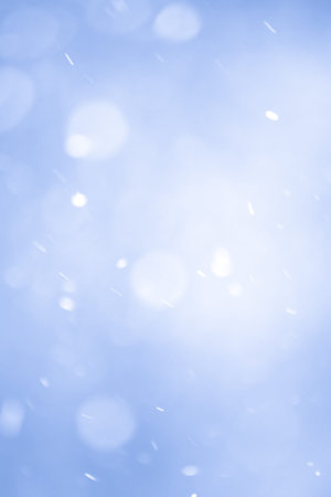 Abstract Blue Christmas Background with Real Snow. Blurred Snowflakes Photo.
