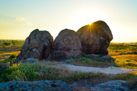 Beautiful Evening Landscape with Big Rocks in the Field at Sunsetの写真素材