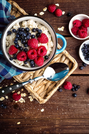 Oatmeal porridge with fresh berries, oats with blueberry and raspberryの写真素材