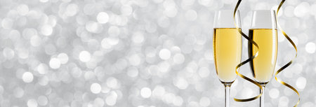 Pair glass of champagne and party curly ribbon. New year celebration or wedding concept.の写真素材