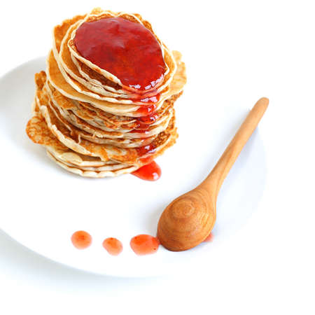 Big pile of tasty pancakes with sweet strawberry syrup on the plate isolated on white background, perfect food for morning mealの写真素材