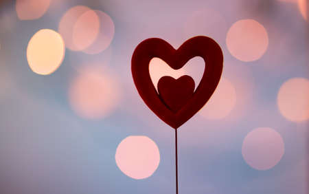 Beautiful red heart over blurry purple bokeh background, romantic greeting card for Valentine's day, love you conceptの写真素材
