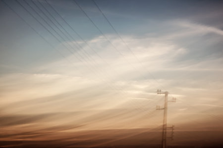 Vintage style photo of an electricity pylon over moody sky, abstract industrial background, power and energy conceptの写真素材