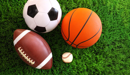 Assortment of sport balls on green grass