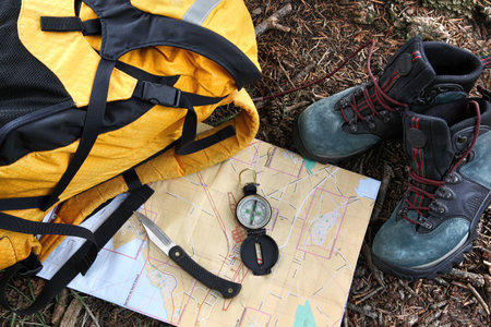 Hiking shoes on map with compass and backpackの写真素材