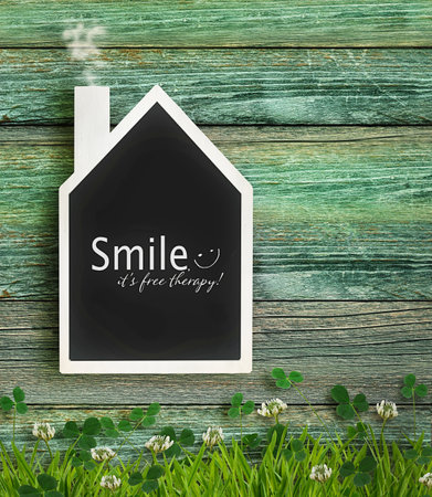 House shaped chalkboard on wood backgroundの写真素材