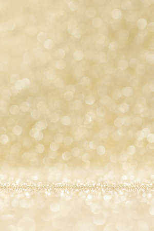Shiny golden bokeh glitter lights abstract background, Christmas New Year party celebration conceptの写真素材
