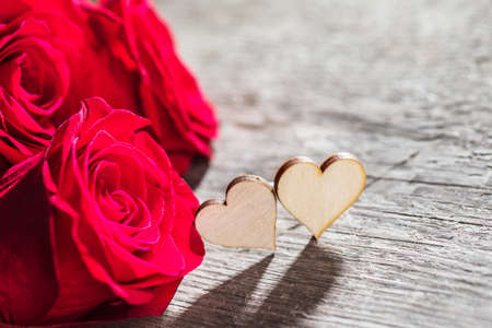 Hearts and red roses on wooden background Valentines day designの写真素材