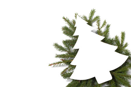 Christmas white fir tree shaped blank card with copy space and decor of fir tree branch isolated on white backgroundの写真素材