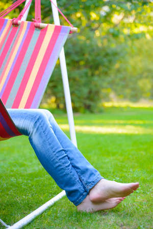 Woman Barefoot Legs on the Green Grass in the Gardenの写真素材