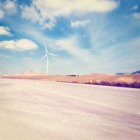 Asphalt Road on the Background of the Modern Wind Turbines Producing Energy in Spainの写真素材
