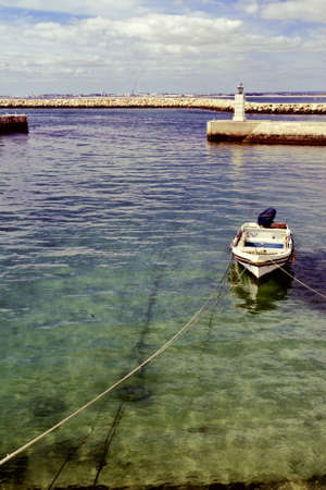 Boat in a Quiet Harbor on the Atlantic Coast of Portugal, Vintage Style Toned Pictureの写真素材
