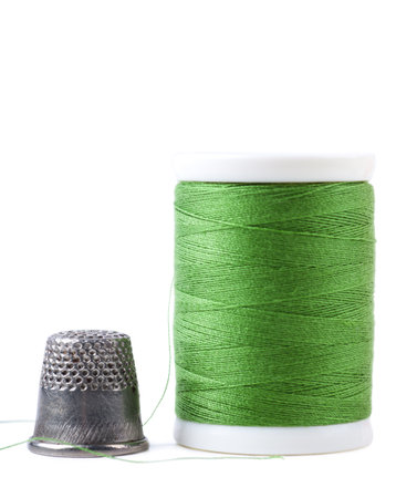 Single spool with green thread and thimbleの写真素材
