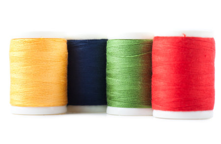 Four spools with green, yellow, blue and red threadsの写真素材