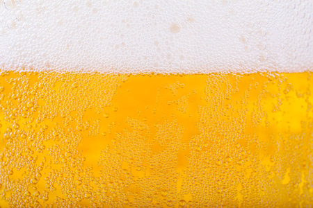 Beer and white froth background. Closeup view.