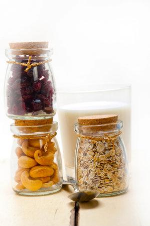 healthy breakfast ingredients milk oat cashew nuts dried cramberry craisinns