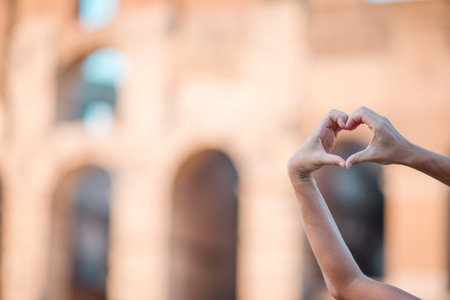 Colosseum or Coliseum background of heart of hands in Rome, Italy. One of the most popular sight in Italyの写真素材