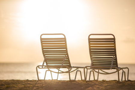 Beach lounge chairs on beautiful tropical beach at sunset