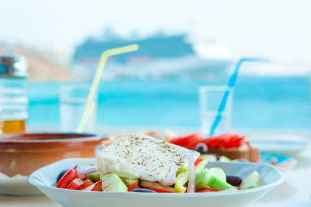 Outdoor cafe on a street of typical greek traditional village in Greece. Coffee with food on table for lunchの写真素材