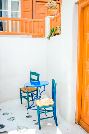 Blue chairs and table on street of typical greek traditional village with white houses on Mykonos Island, Greece, Europeの写真素材