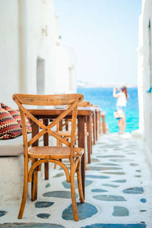 Benches with pillows in a typical greek outdoor cafe in Mykonos with amazing sea view on Cyclades islandsの写真素材