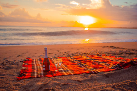 Having a picnic on the beach at sunsetの写真素材