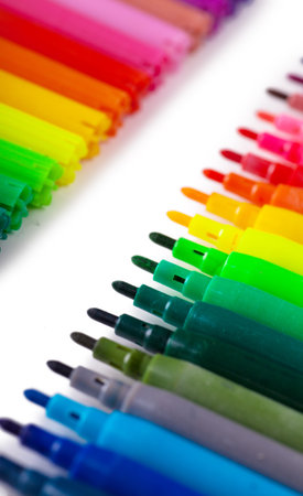 Closeup view of a row of colorful felt tip pens over white background