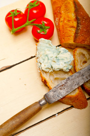 fresh blue cheese spread ove french baguette with cherry tomatoes on sideの写真素材
