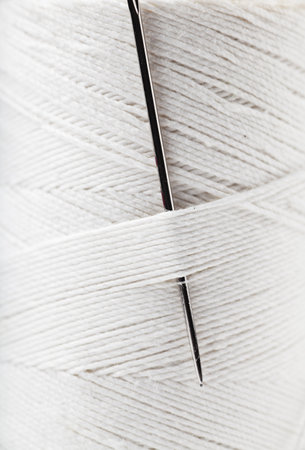 Macro view of reel of white thread with needleの写真素材