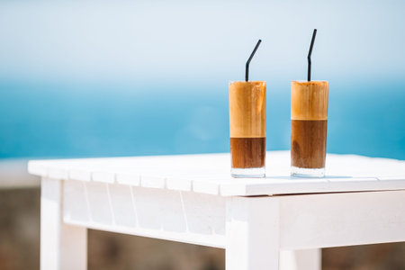 Cold coffee latte on wooden table with sea background