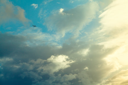 Airplane in the blue sky with cloudsの写真素材