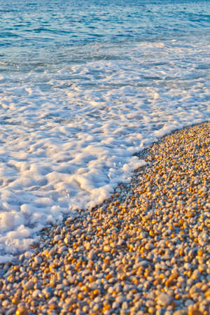 Pebble stones by the sea. Waves of blue Tyrrhenian sea. Calabria, Italy.の写真素材