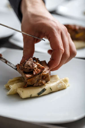 Chef is making meat dish on commercial kitchenの写真素材