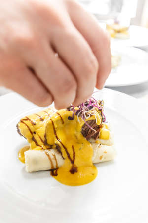 Chef finishing her plate and almost ready to serve at the tableの写真素材