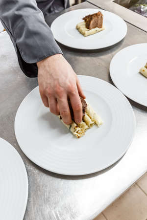Chef preparing a meal on restaurant kitchen tableの写真素材