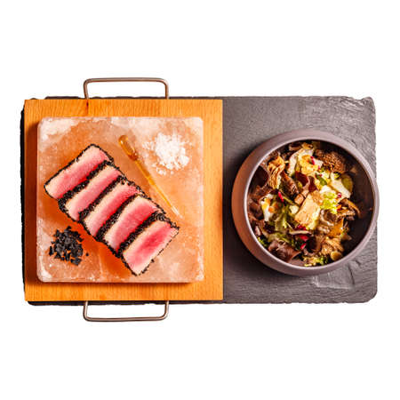 Red tuna rolled in black sesame seeds and salad with dried mushrooms on white backgroundの写真素材
